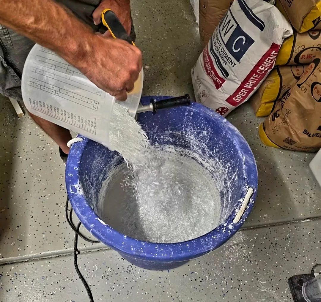Mike pouring chopped glass fiber into a bucket of white-cement mix