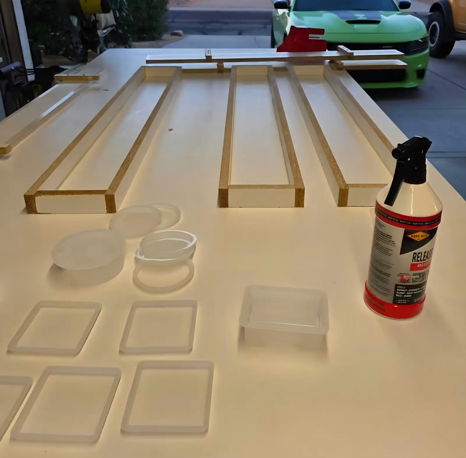 Handmade wood forms and plastic coaster molds laid out on a shop table