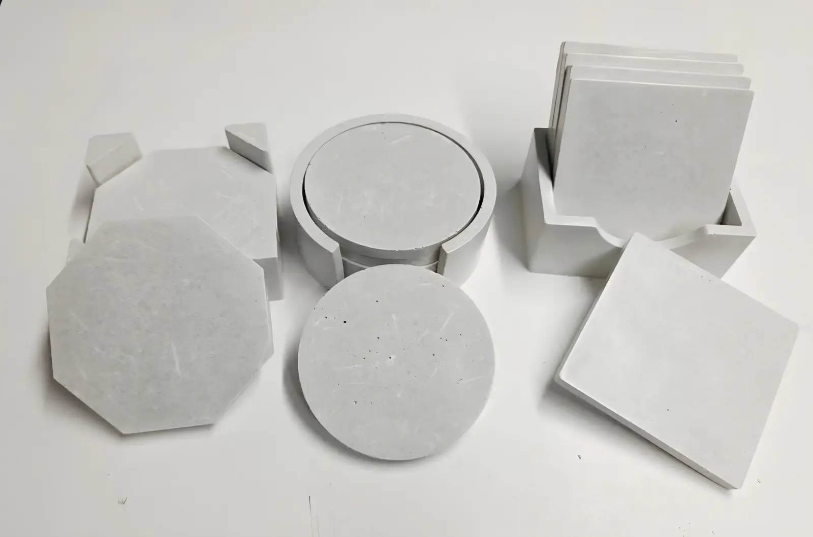 Sets of grey concrete coasters in round, square and octagon shapes with holders